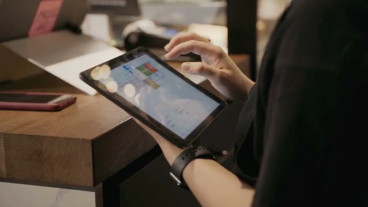 An operator going through sales reports on a tablet