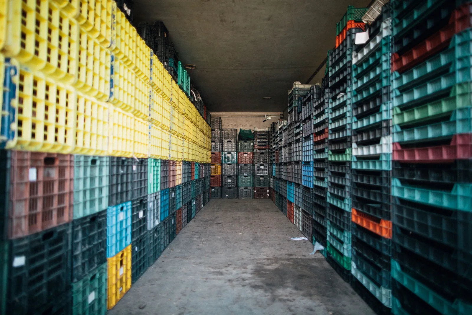 Depo koridorunda üst üste dizilmiş plastik kasalar